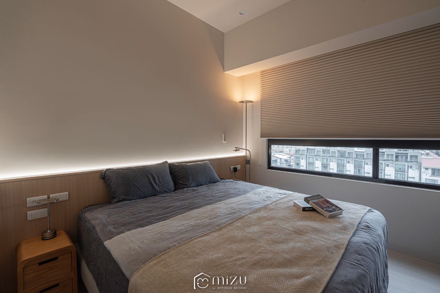 臥室床鋪與窗邊全景，木質床頭櫃、灰色床組與水平窗景搭配淺木紋地板 | GP7109 萊博淺橡 超耐磨木地板 | 明峻地板
