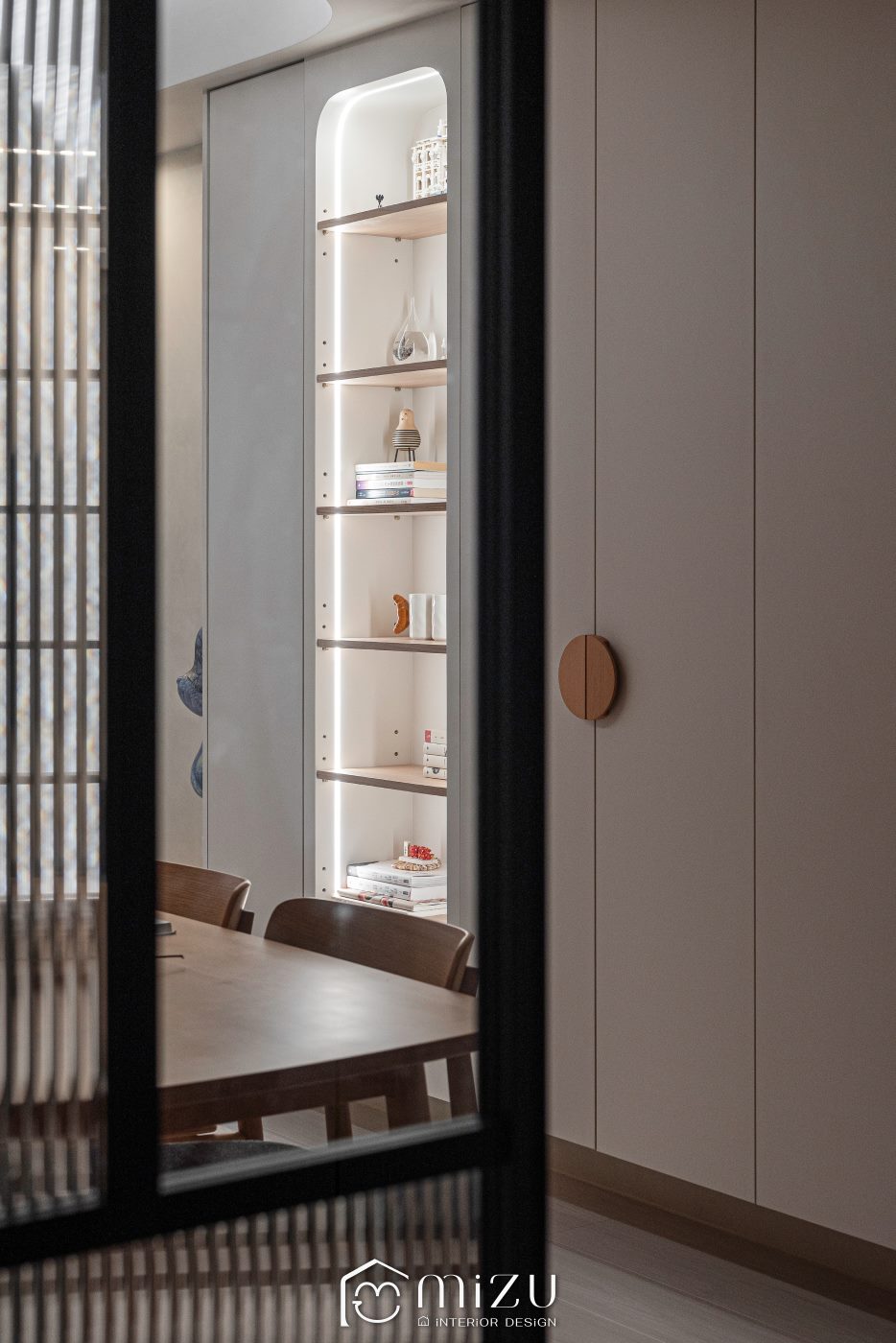 餐廳展示櫃側面特寫，弧形層架、暖光收藏展示與圓形木把手形成精緻端景 | MiZU 暖弧小日住宅空間 | 明峻地板