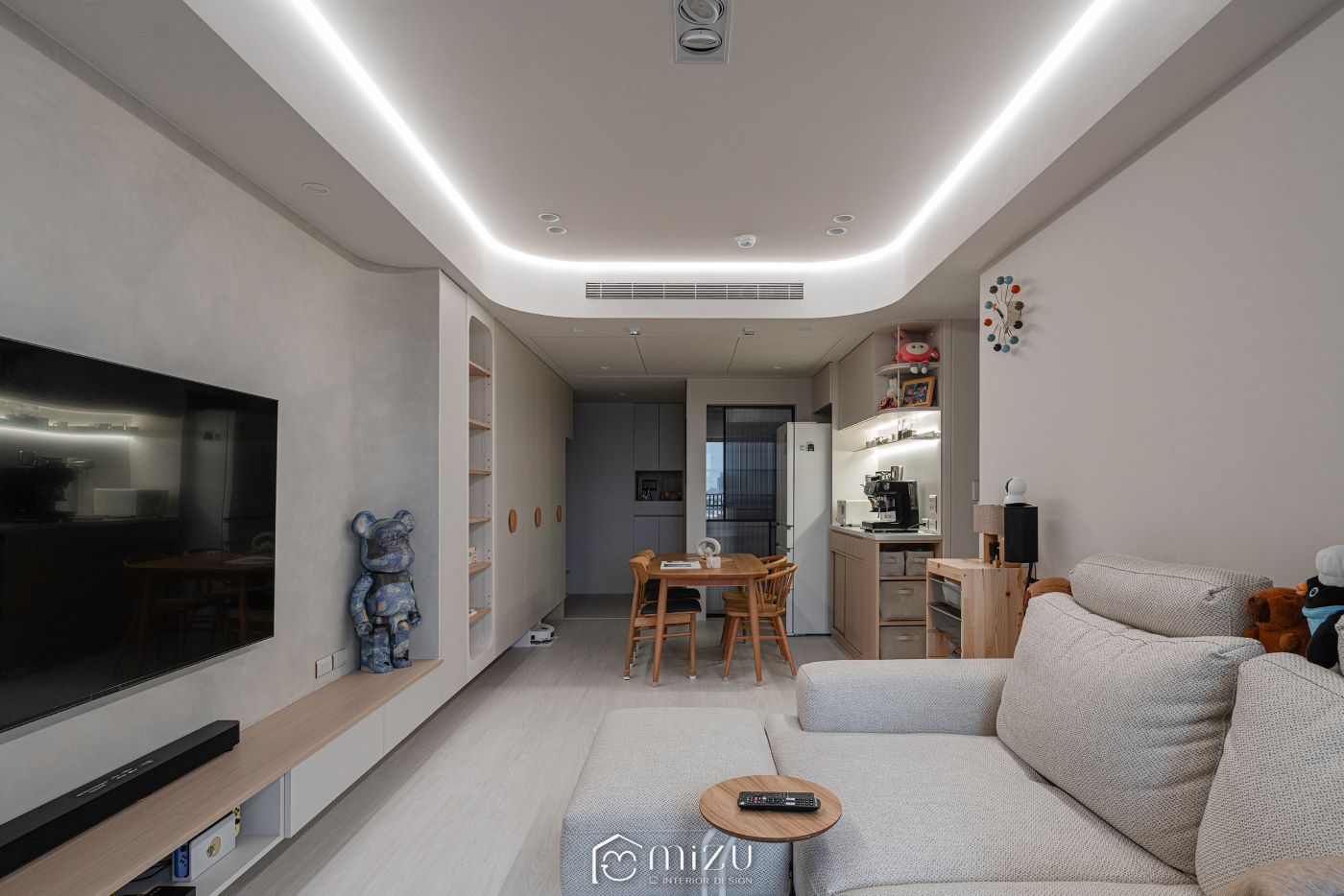 客廳沙發望向餐廳與廚房，環形間接照明搭配淺木地坪 | GP7109 萊博淺橡 超耐磨木地板 | 明峻地板