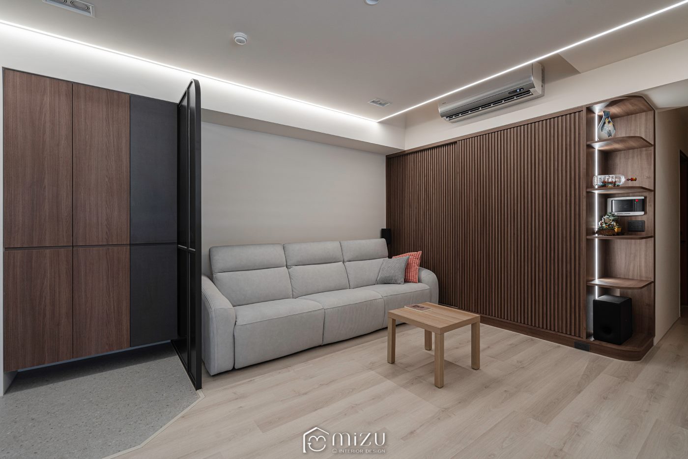 客廳與落塵區交界，玻璃屏風、木格柵牆與灰色沙發 | EHL133 科爾皮諾白橡 超耐磨木地板, GU3112 水磨石灰 SPC石塑地板 | 明峻地板